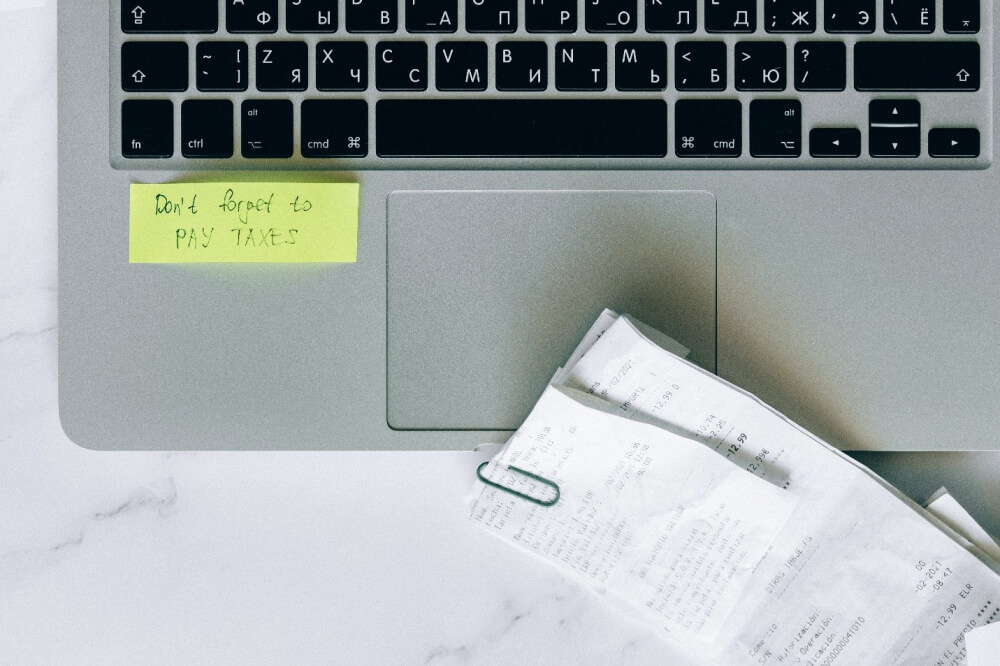 A computer with papers and a paper clip — Small Business Compliance