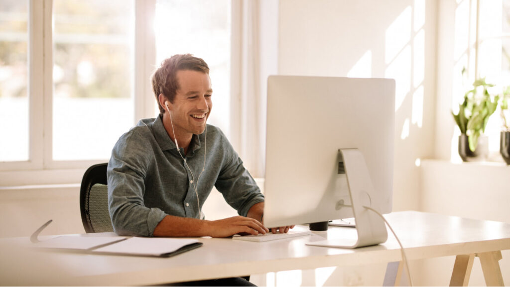 Man wearing earphones and looking at a computer screen — Financial Statement
