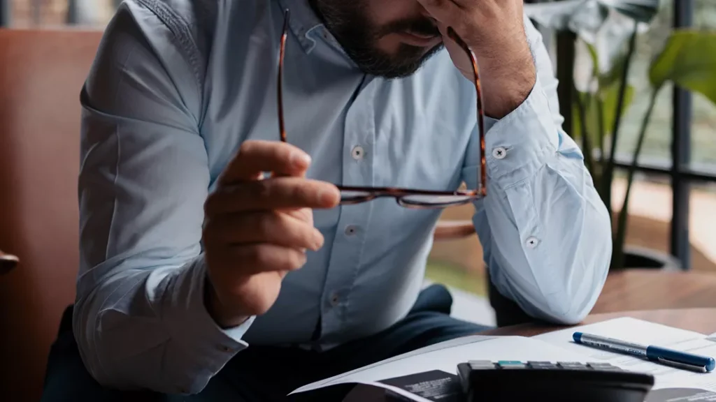 A person holding his glasses