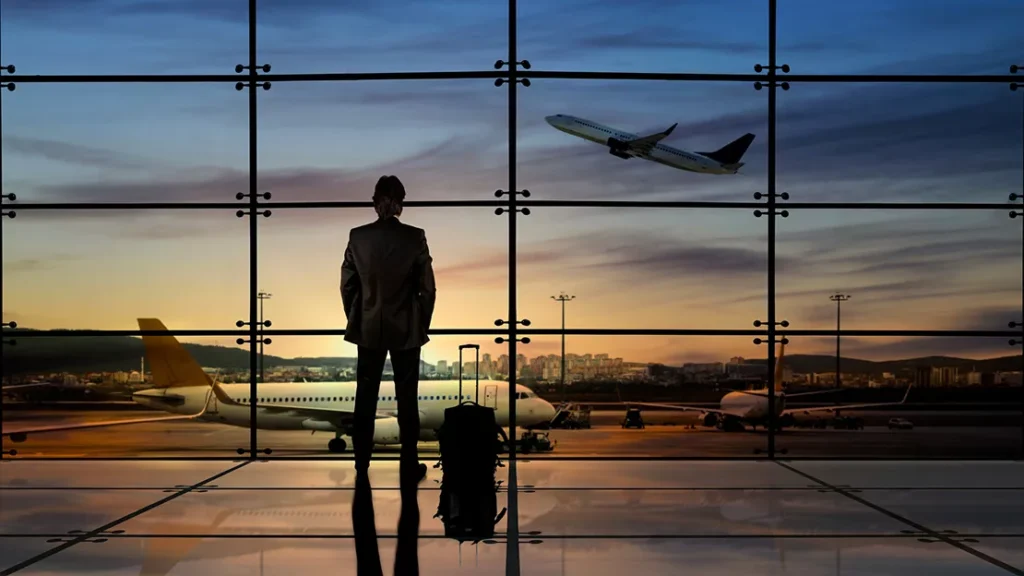 A man is watching an airplane take off