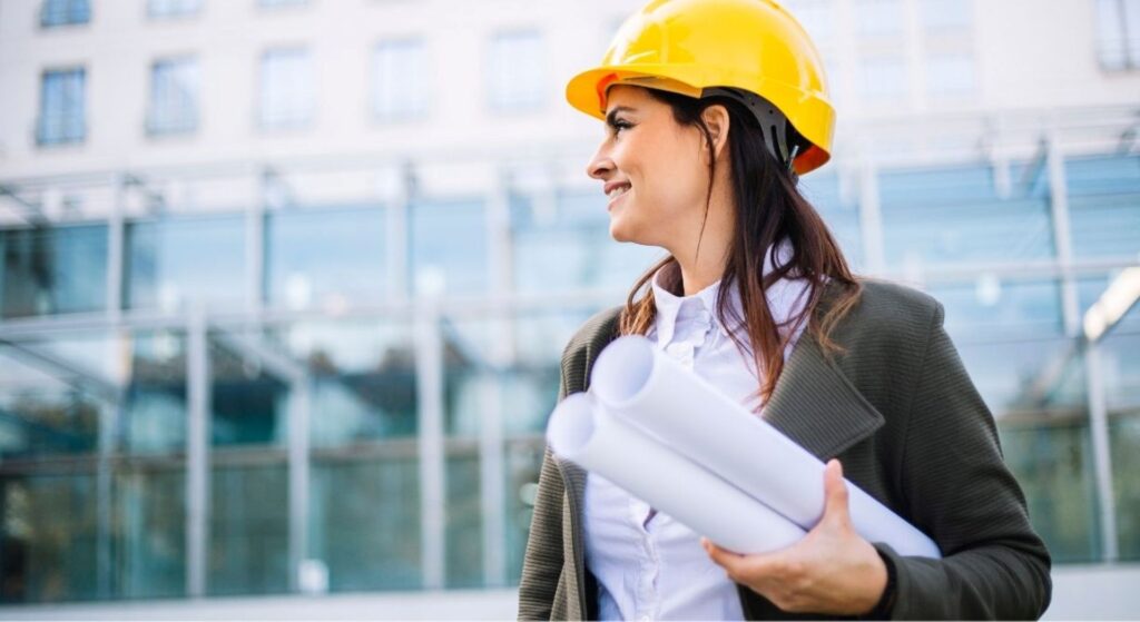 Woman wearing hard hat and holding a blueprint